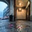 An empty rain-wet stone arcade overlooking Hong Kong harbour lights