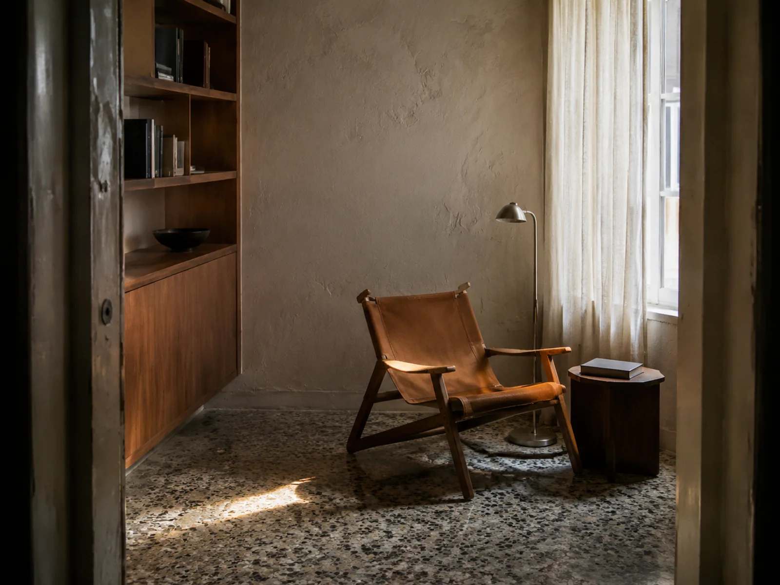 Morning light in a compact modernist Lisbon reading room photographed from the doorway